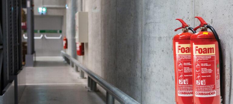Fire extinguisher correctly mounted on a wall in a commercial premises at the proper height